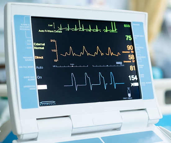 A piece of medical equipment monitor shows heart pulses and signals.