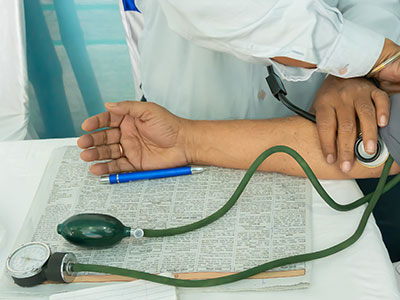 A close-up shot of a medical expert monitoring the blood pressure of a patient.