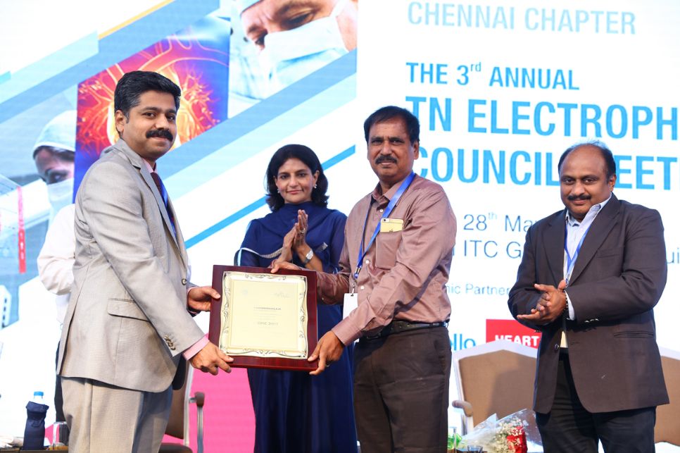 Photo of Dr. Karthigesan A.M. being felicitated at a conference.